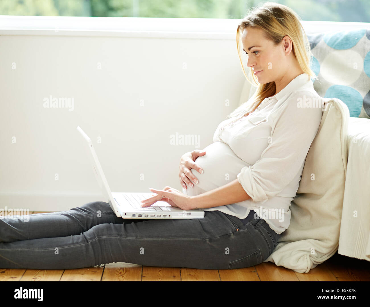 Schwangere Frau mit Laptop-computer Stockfoto