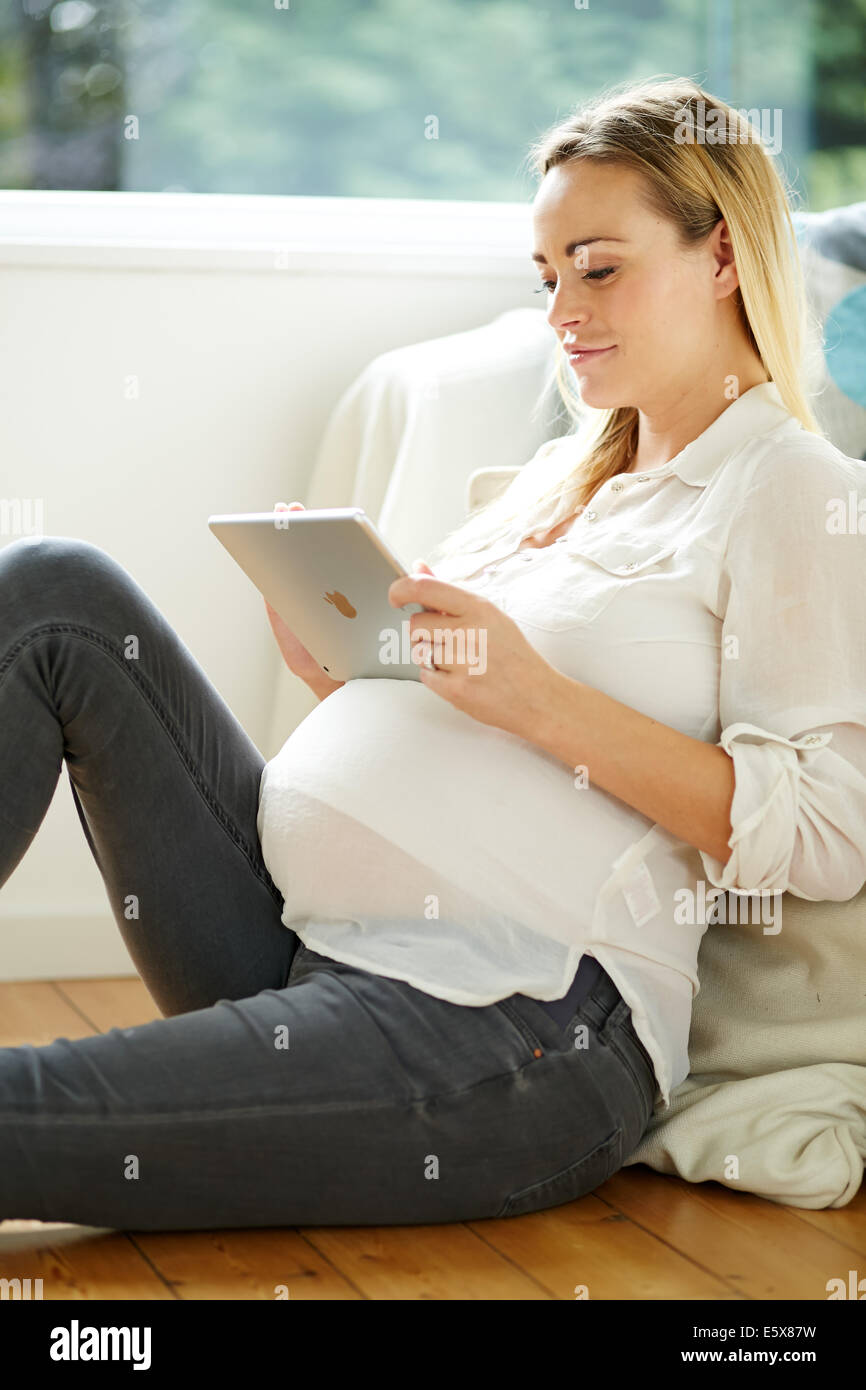 Schwangere Frau mit dem iPad Stockfoto