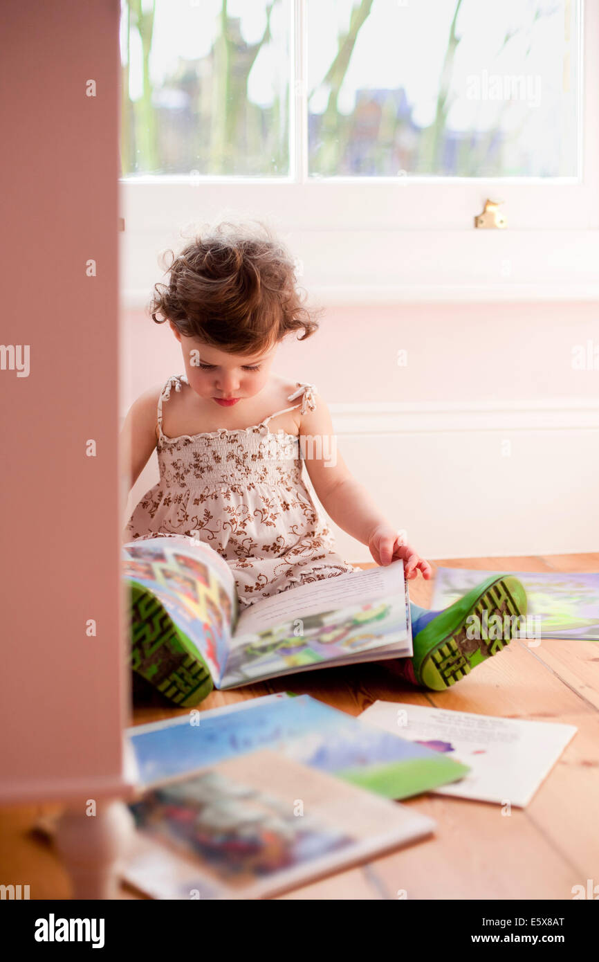 Weiblichen Kleinkind lesen Märchenbücher im Schlafzimmer Stockfoto