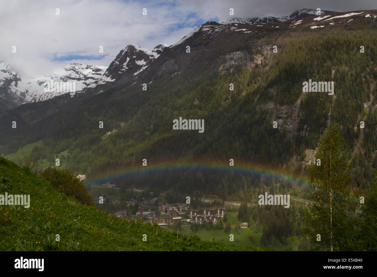Regenbogen über Leukerbad in den Schweizer Alpen Stockfoto