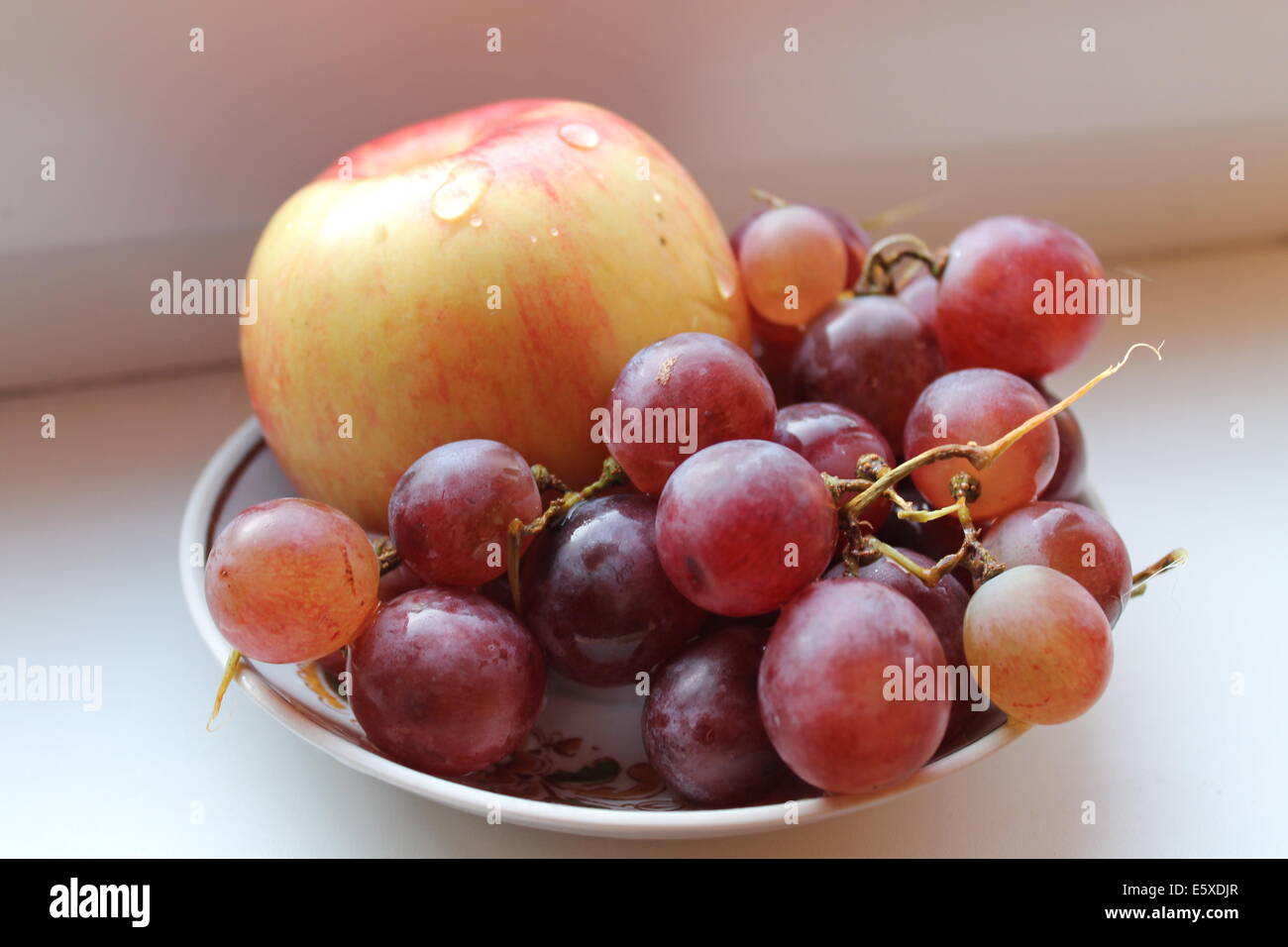 appetitlich fröhlich frischen Früchten gelbe Tafelapfel mit violetten Cluster süßes Fruchtfleisch Traube Stockfoto