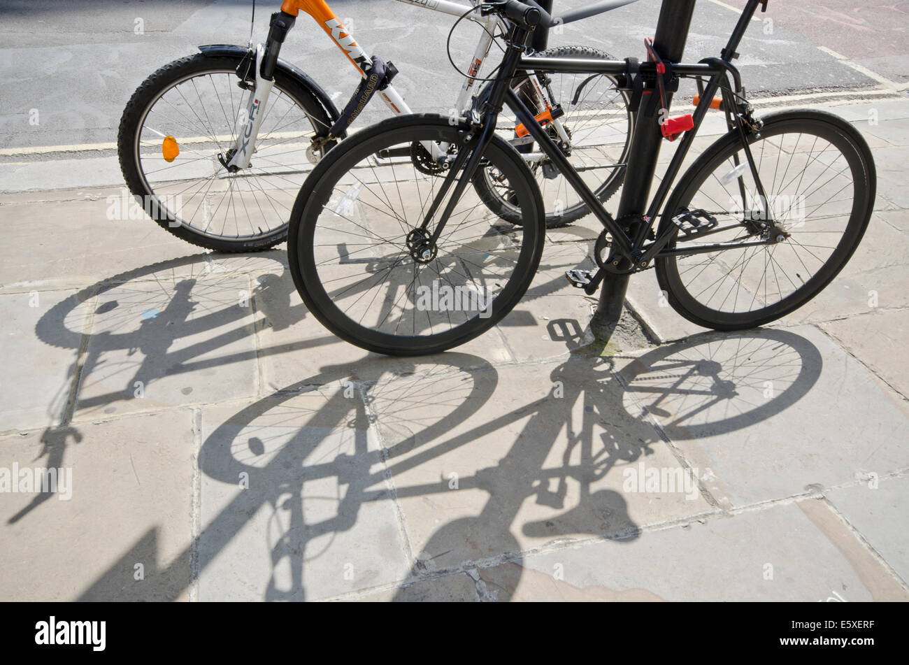 Fahrräder und Schatten in einer städtischen Umgebung Stockfoto