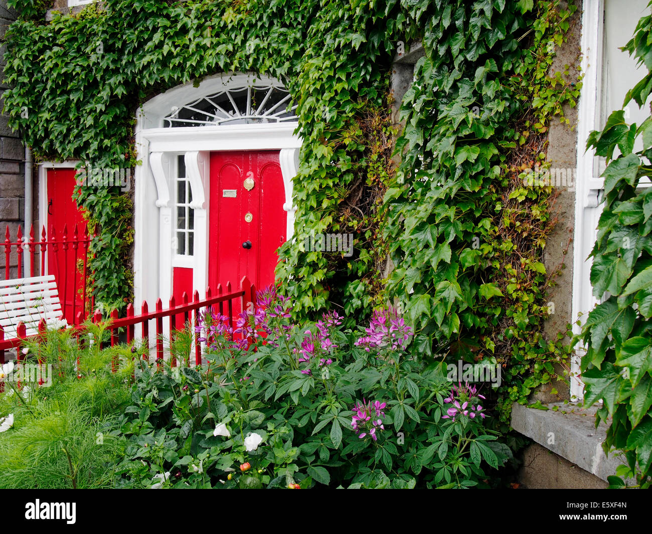 Georgianisches Haus am Oktogon, Westport Stadt, County Mayo, Connaught, Irland mit lebhaft rote Tür und Eisengitter. Stockfoto