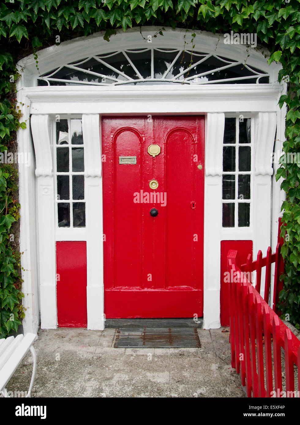 Georgianisches Haus am Oktogon, Westport Stadt, County Mayo, Connaught, Irland mit lebhaft rote Tür und Eisengitter. Stockfoto