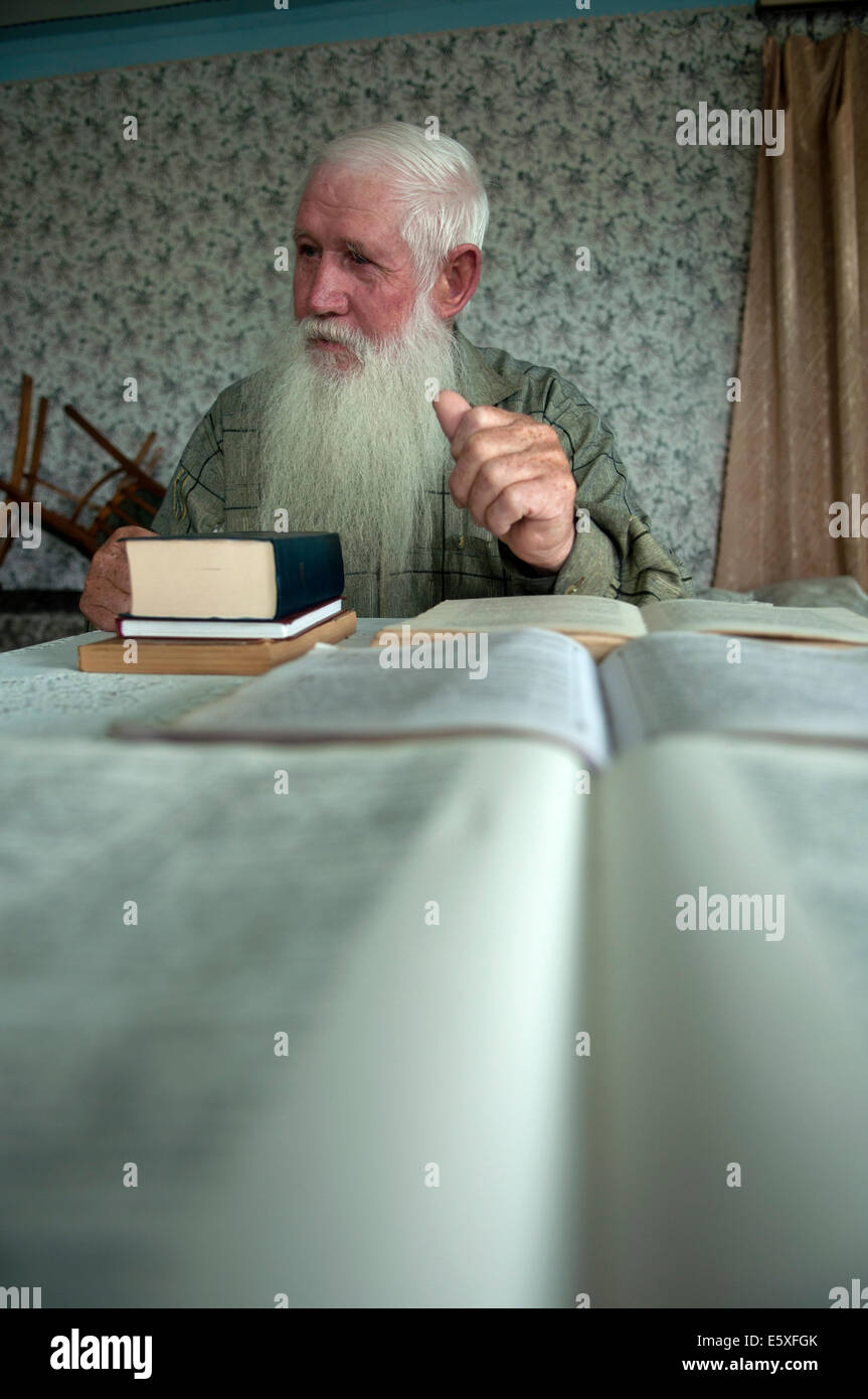 Bibeln immer auf dem Tisch eines alten Molokan Mann mit weißem langem Bart öffnen, fioletovo Dorf, Armenien Stockfoto