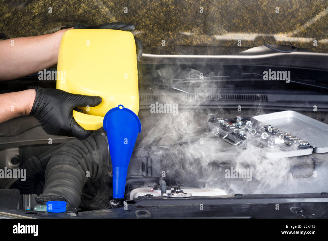 Mechaniker gießt Kühlerschutzmittel in einem überhitzten Auto Heizkörper in einem Versuch, abkühlen lassen und den Dampf zu stoppen. Stockfoto