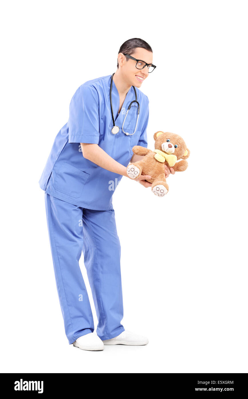 In voller Länge Portrait von einem jungen männlichen Arzt geben einen Teddybär Stockfoto