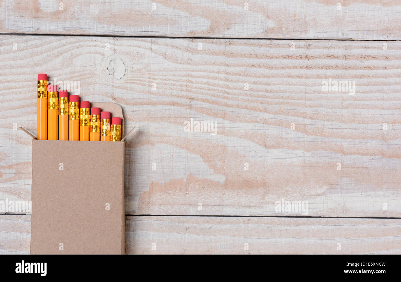Hohen Winkel Schuss von einem Karton neue Bleistifte auf einem weiß getünchten Holz Schreibtisch. Die Box ist set ot verlassen viele Kopie s rechts Stockfoto