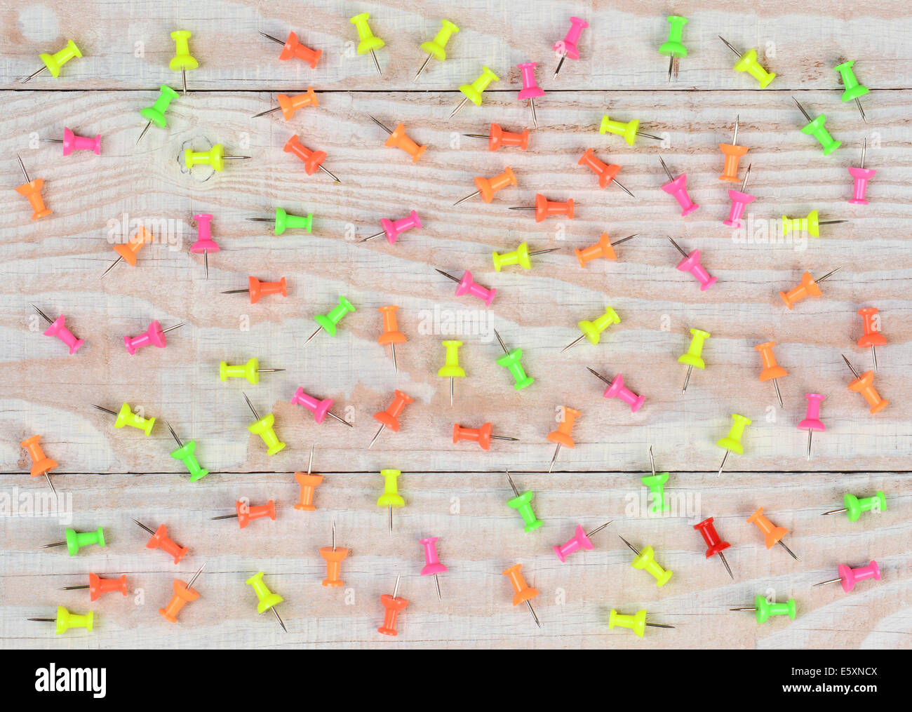 Eine zufällige Anordnung von multi-rosafarbig-Push-Pins auf einem rustikalen Holztisch weiß getünchten. Hohen Winkel im Querformat gedreht. Stockfoto