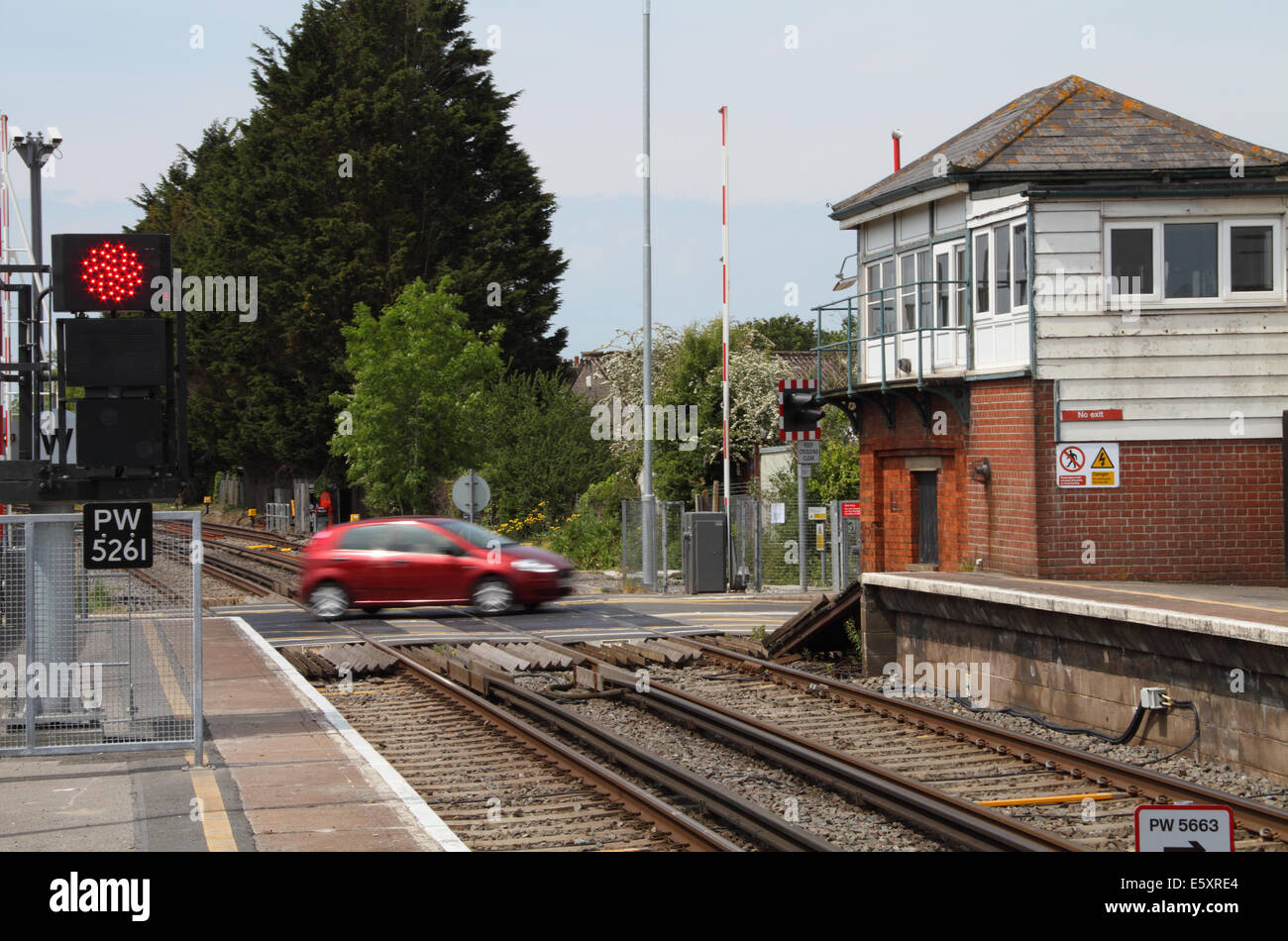 Ein Auto überquert die Gleise am Bahnübergang Wolle Station, East Dorset, England Stockfoto