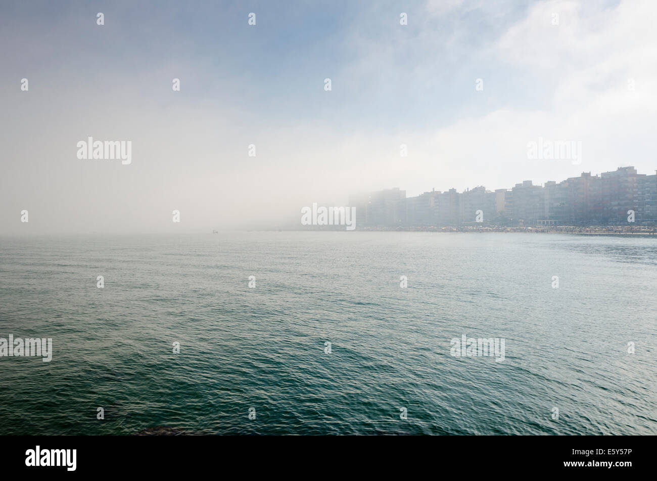 Seenebel, nähert sich den Strand mit Hochhäusern im Hintergrund im Sommer. Costa Del Sol, Spanien. Stockfoto