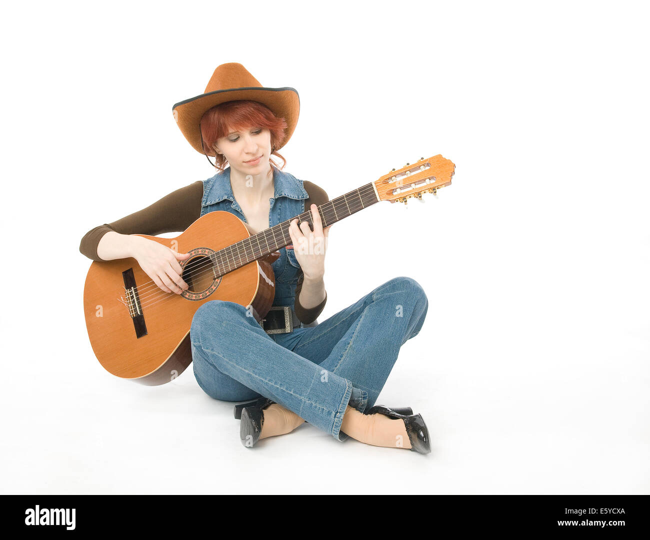 Frau sitzt auf einer Etage und Gitarre spielen Stockfoto