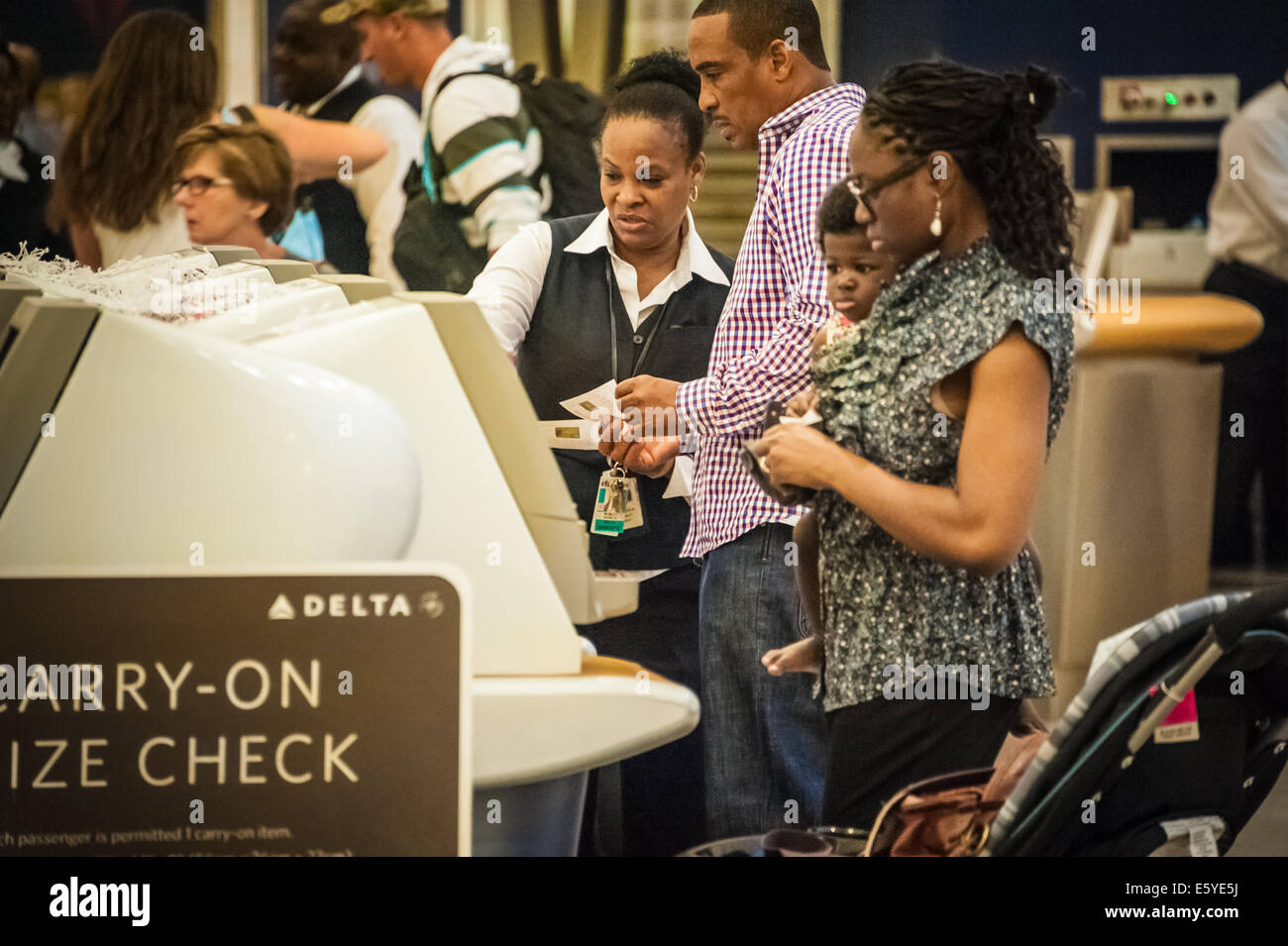Delta Airlines Mitarbeiter unterstützen Reisende an den Check-in-Automaten am Atlanta International Airport (weltweit am stärksten frequentierte Flughafen). Stockfoto