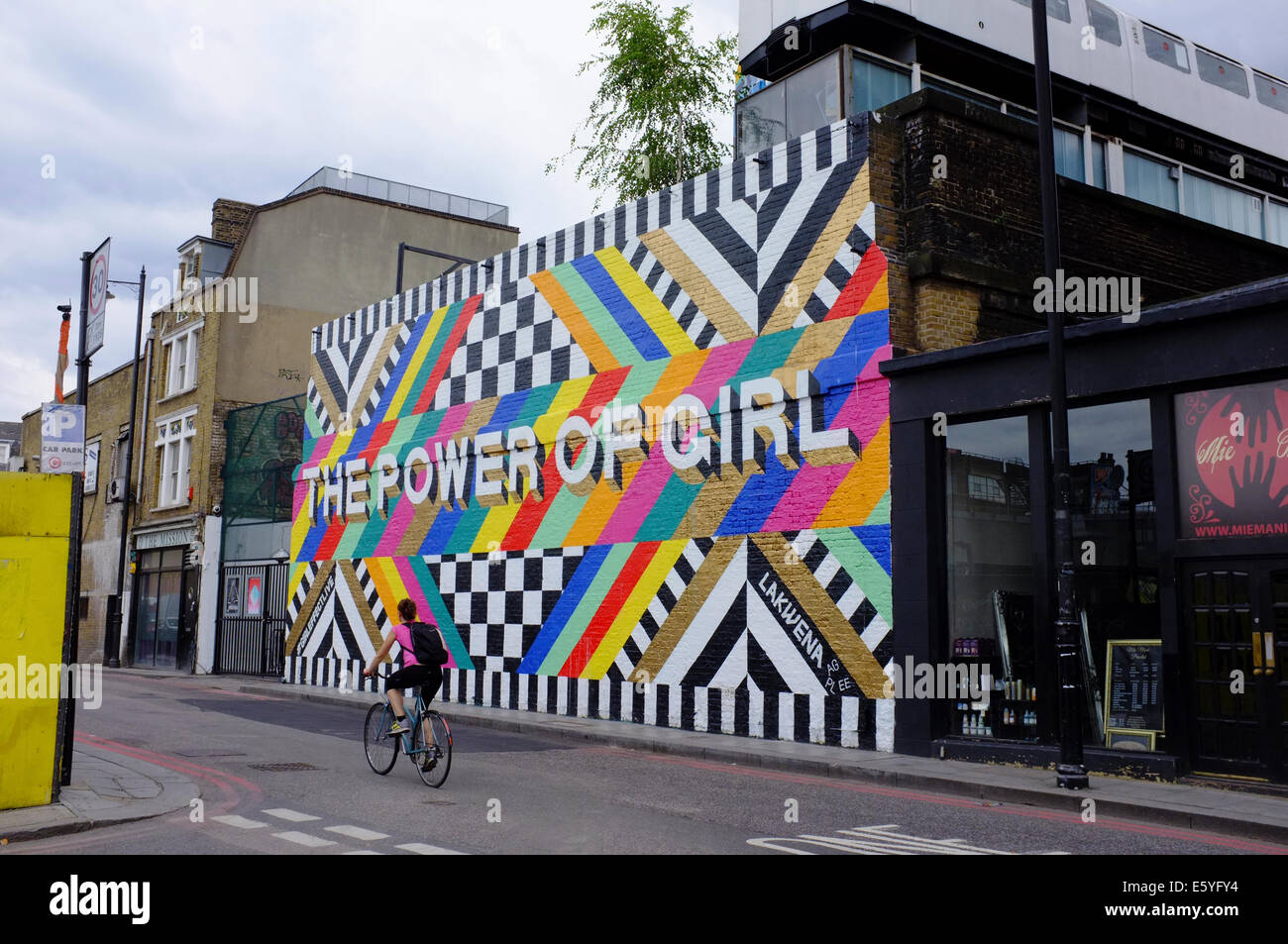 DIE POWER von GIRL-Graffiti-Kunst in Shoreditch mit weiblichen Radfahrer Stockfoto