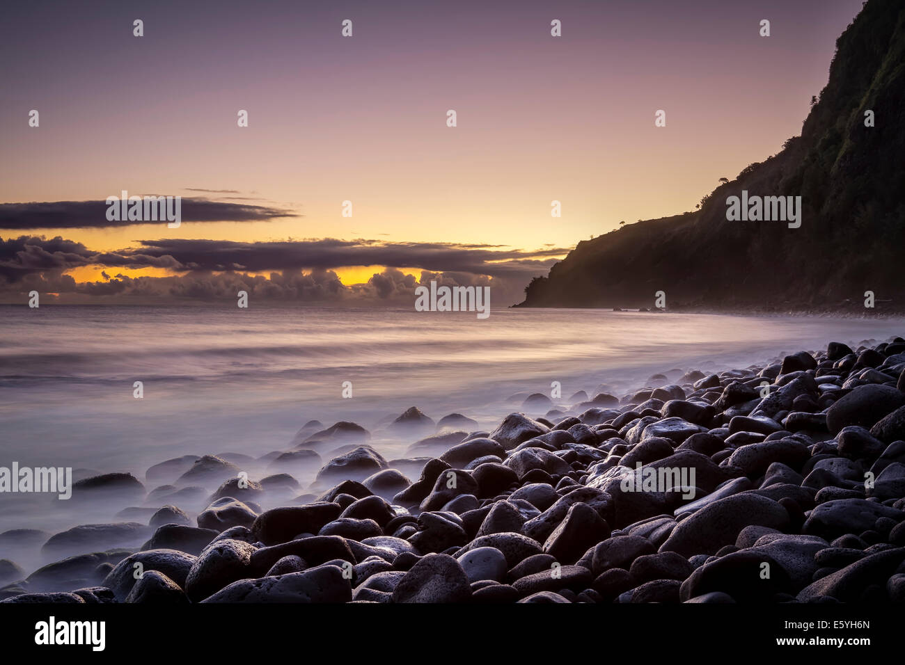 Sonnenaufgang am einsamen Strand im Waipi'o Valley, Big Island, Hawaii. Wellen an den Felsen. Stockfoto