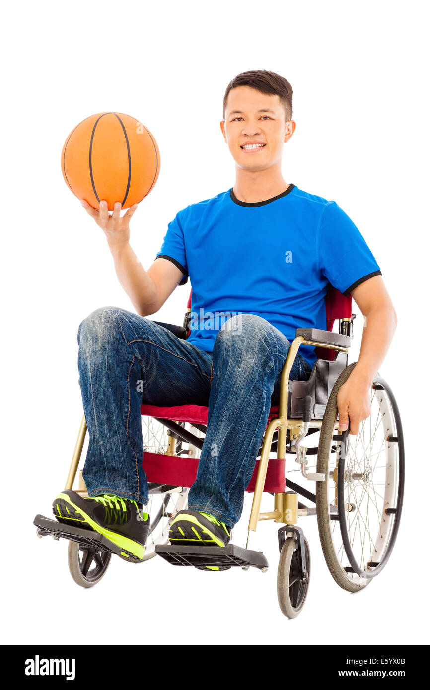 hoffnungsvoller junger Mann sitzt auf einem Rollstuhl mit einem basketball Stockfoto