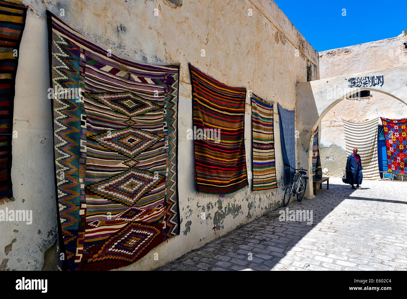 Afrika, Nordafrika, Maghreb, Governorat Medenine, Insel Djerba. Houmt Souk. Teppiche auf der Wand angezeigt. Stockfoto