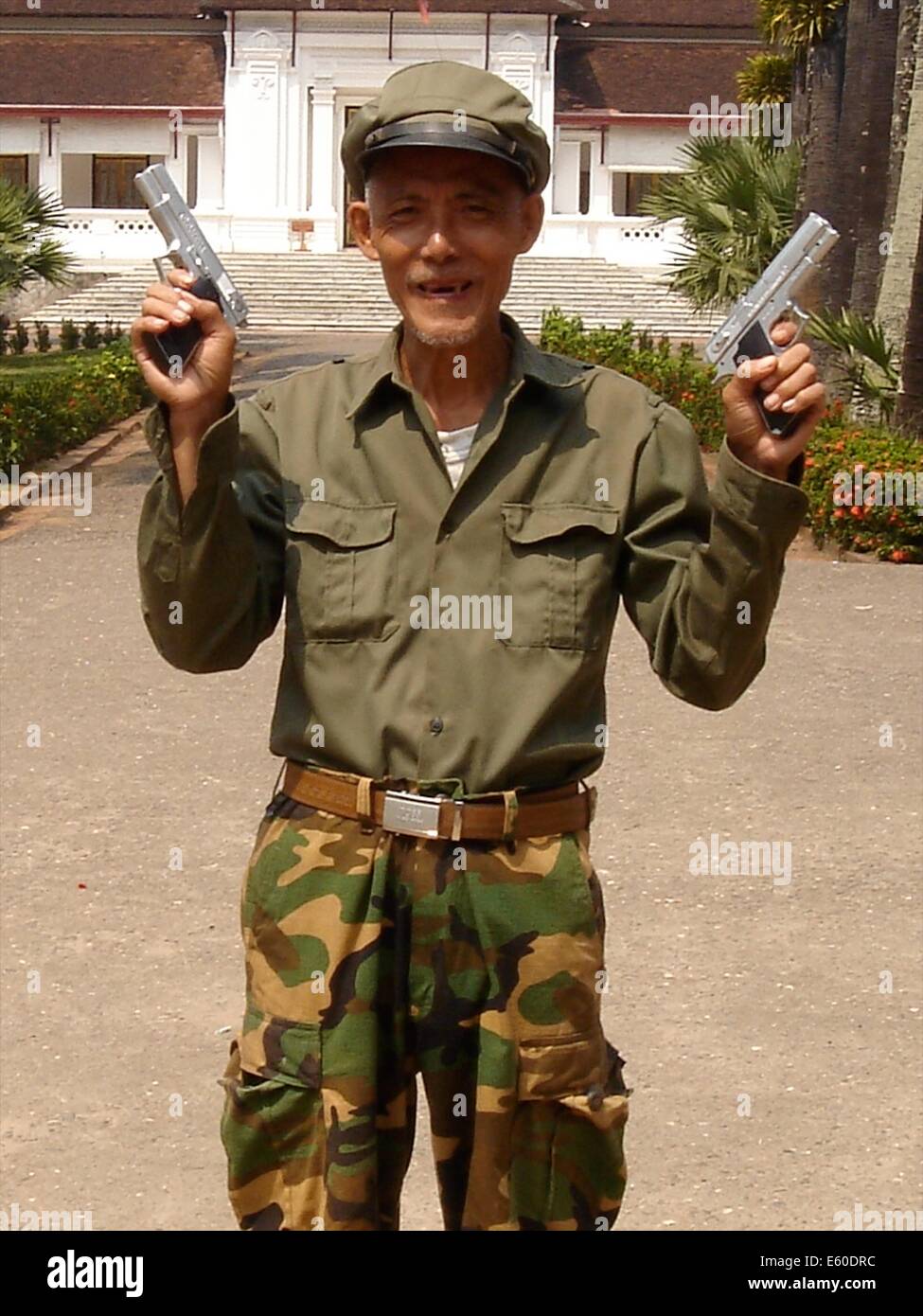 Ein Wachmann Schuhe off seine Waffen in der Stadt Luang Rachentupfer, Laos Stockfoto