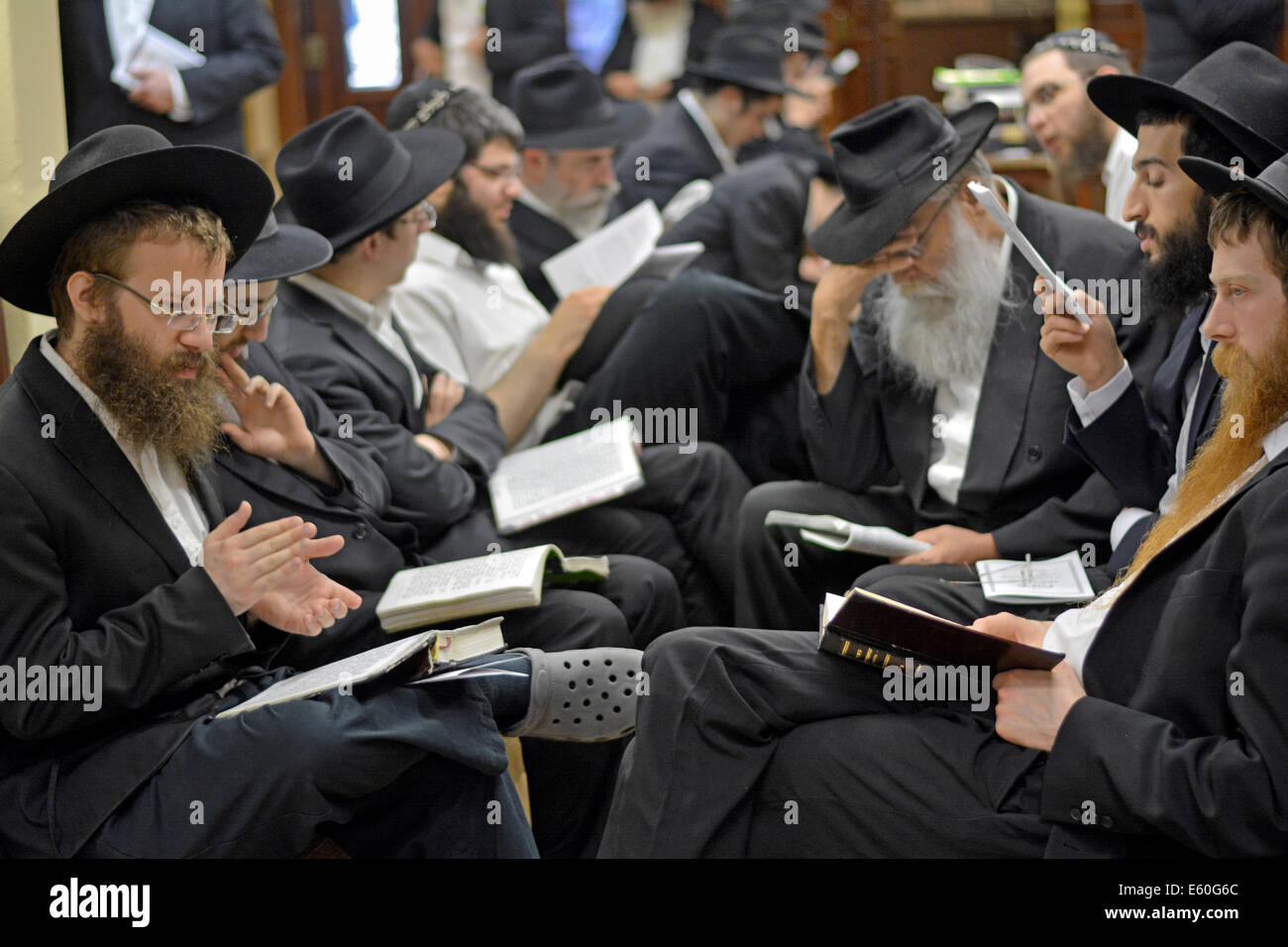 Junge jüdische Männer beten während Tisha B'Av Dienste in einer Synagoge in Brooklyn, New York, USA Stockfoto