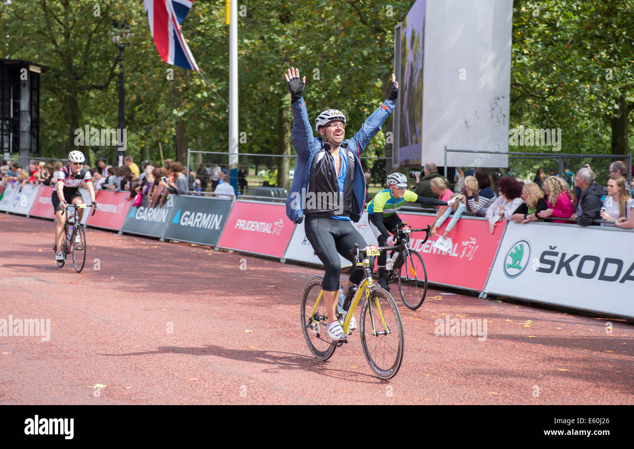 Die Mall, London UK. Sonntag, 10. August 2014. Sintflutartige Regenschauer Hits London als frühe Fahrer erreichen The Mall am Ende einer zermürbenden London-Surrey 100 Fahrt. Eine offizielle Erklärung von Event-Regisseur Hugh Brasher besagt: nur widerwillig haben wir beschlossen, verkürzen den Weg für die aufsichtsrechtliche RideLondon-Surrey 100 heute 86 Meilen und verpassen Sie den Abschnitt der Route, die Leith Hill und Box Hill enthält. Fahrer zu nähern die Ziellinie in Sonnenschein zwischen Starkregen. Bildnachweis: Malcolm Park Leitartikel/Alamy Live-Nachrichten. Stockfoto