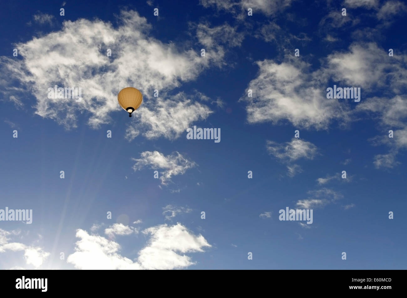 hellen Heißluftballon hoch in den Himmel mit einem blauen Himmel und Wolken Stockfoto