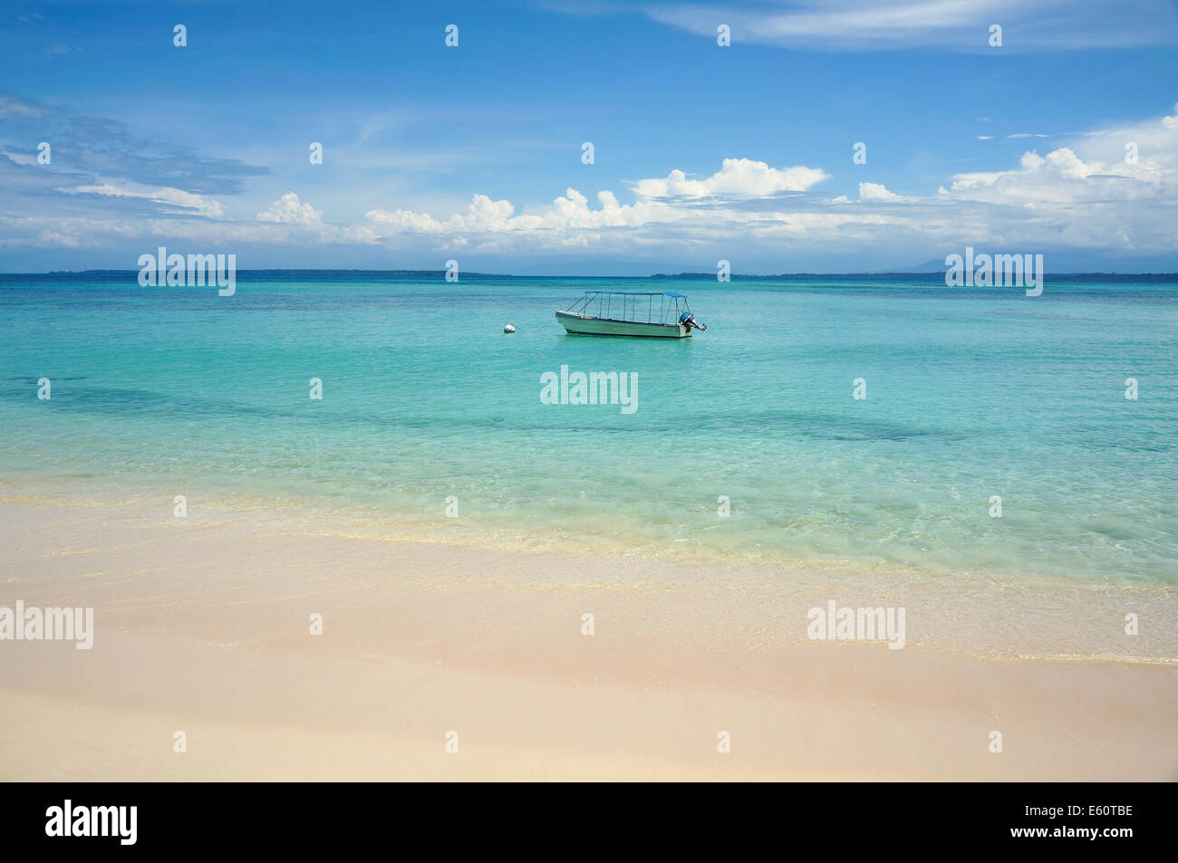 tropischer Strand mit türkisfarbenem Wasser und ein Boot am Liegeplatz Boje Stockfoto