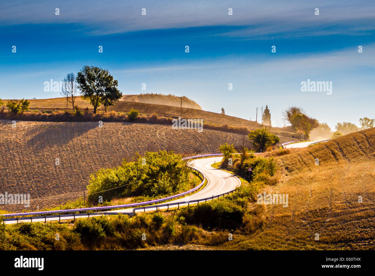 Kurvenreiche Straße und Hügel an einem Sommertag in Crete Senesi in Toskana, Italien Stockfoto