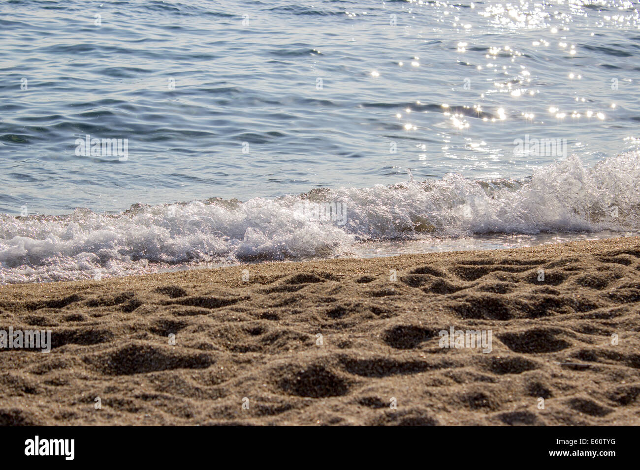 Welle des Meerwassers auf eine klare Kiesstrand am Sommertag Stockfoto