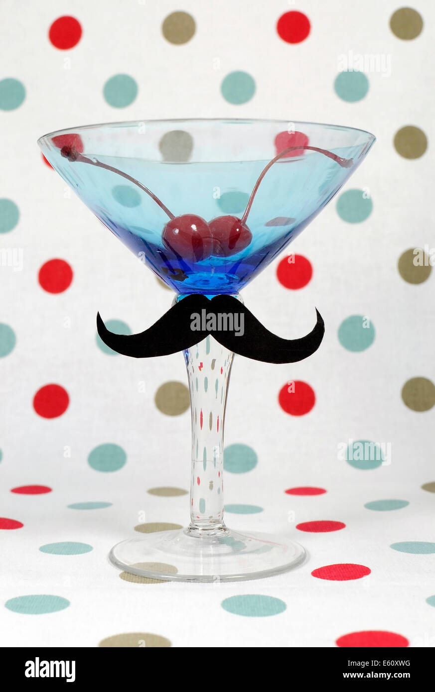 Posh Schnurrbart auf blauen Vintage Martini cocktail Glas mit Maraschino-Kirschen Polka Dot im Hintergrund Stockfoto