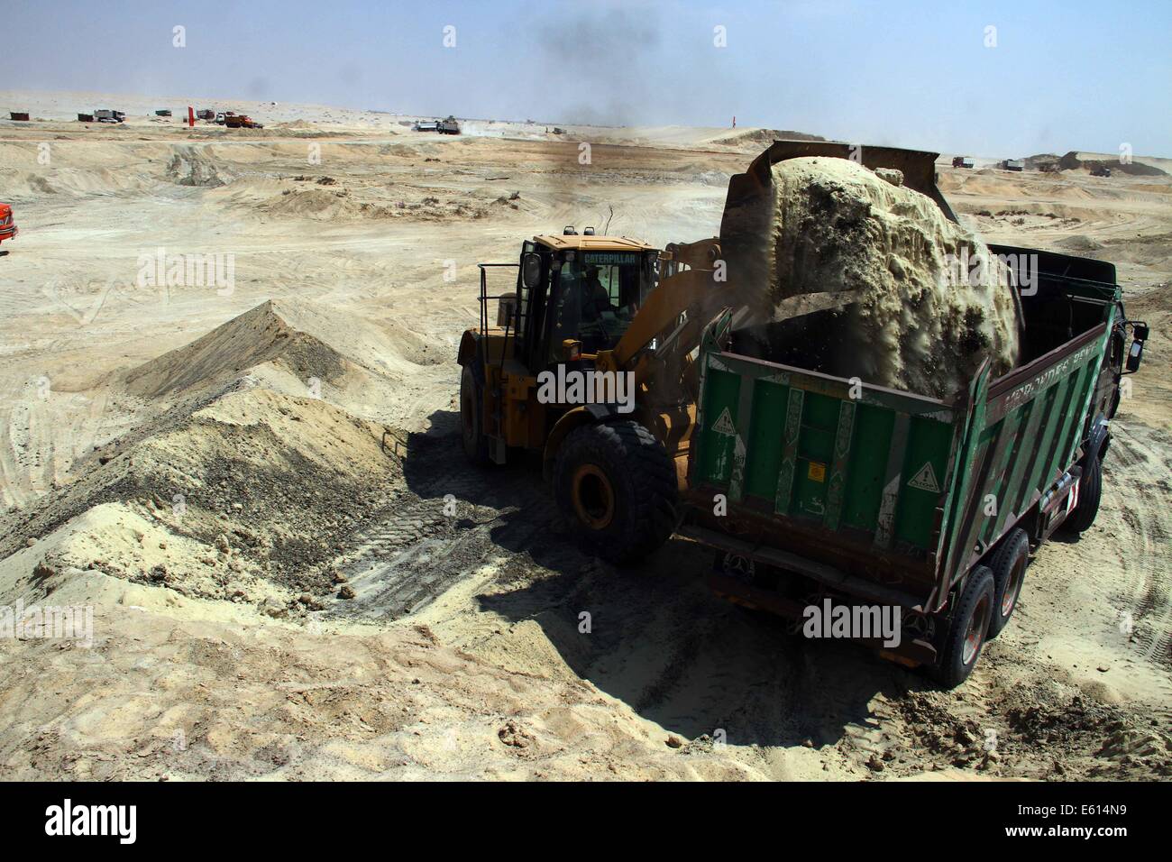 Ismailia, Ägypten. 10. August 2014. Ein ägyptischer Arbeiter trägt Sand auf der Baustelle des Projektes "Neue Suez Canal" in Ismailia Hafenstadt, nordöstlich von Kairo, Ägypten, am 10. August 2014. Ägyptens Präsident Abdel Fattah al-Sisi stellte am vergangenen Dienstag den Bau einer 72 km "neue Suez-Kanal" Verkehr neben dem bestehenden Wasserstraße, die das Rote Meer mit dem Mittelmeer verbindet beschleunigen und Ägyptens angeschlagenen Wirtschaft ankurbeln soll. © Ahmed Gomaa/Xinhua/Alamy Live-Nachrichten Stockfoto