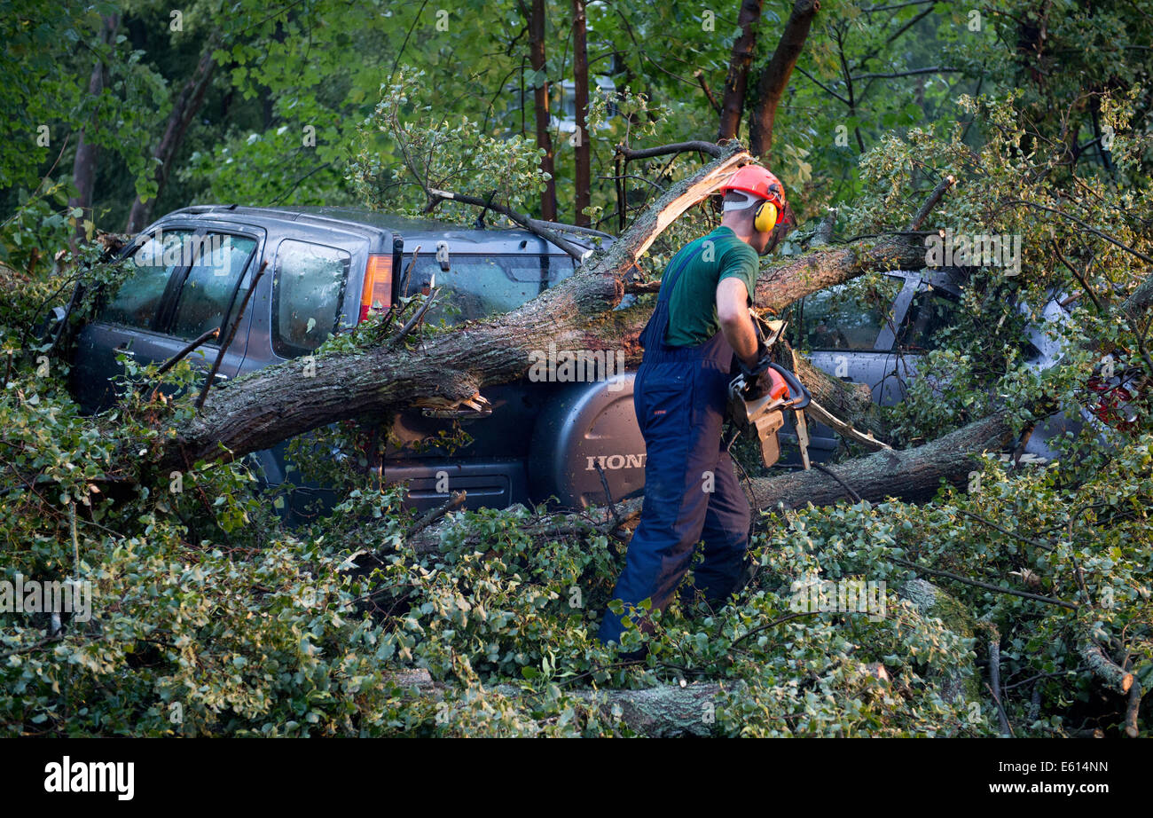 Bad Schwalbach, Deutschland. 10. August 2014. Ein Feuerwehrmann versucht, zerstörten Autos in Bad Schwalbach, Deutschland, 10. August 2014. Ein Tornado gemeinsam mit einer regen Sturm verursachte Schäden in Millionenhöhe in den Kurort. Zahlreiche Autos wurden beschädigt, Dächer der Häuser abgenommen und Waldflächen zerstört. Foto: Boris Roessler/Dpa/Alamy Live News Stockfoto