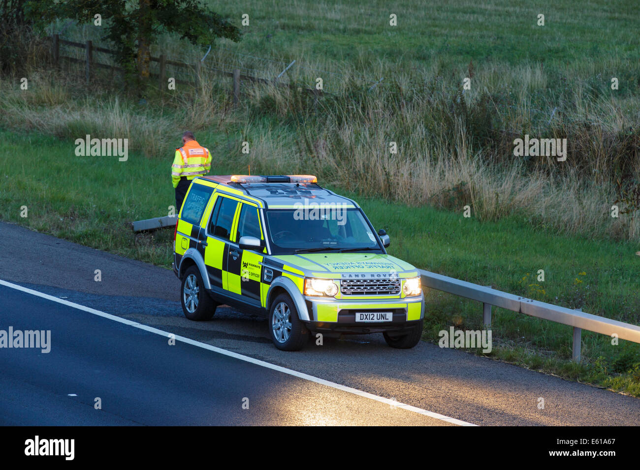 Ein Highways Agency Landrover Fahrzeug besucht die Szene von einem Verkehrsunfall auf der Autobahn UK in der Abenddämmerung. Stockfoto