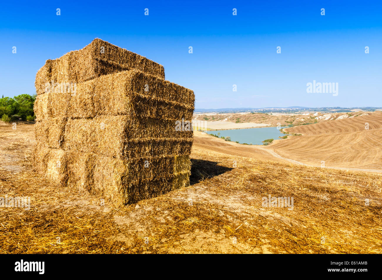 Strohballen und kleinen See im Sommer in der Nähe von Asciano in Crete Senesi, Toskana, Italien Stockfoto