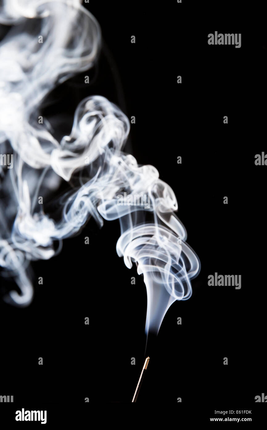Thread von Rauch aus gerade noch sichtbar Räucherstäbchen vor schwarzem Hintergrund Stockfoto