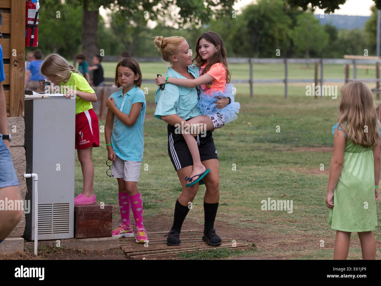 Weibliche Ratgeber hält Wohnmobil Mädchen in Tracht am Camp Champions, ein Schlaf-über Sommer-Camp am See LBJ in zentralen TX Stockfoto