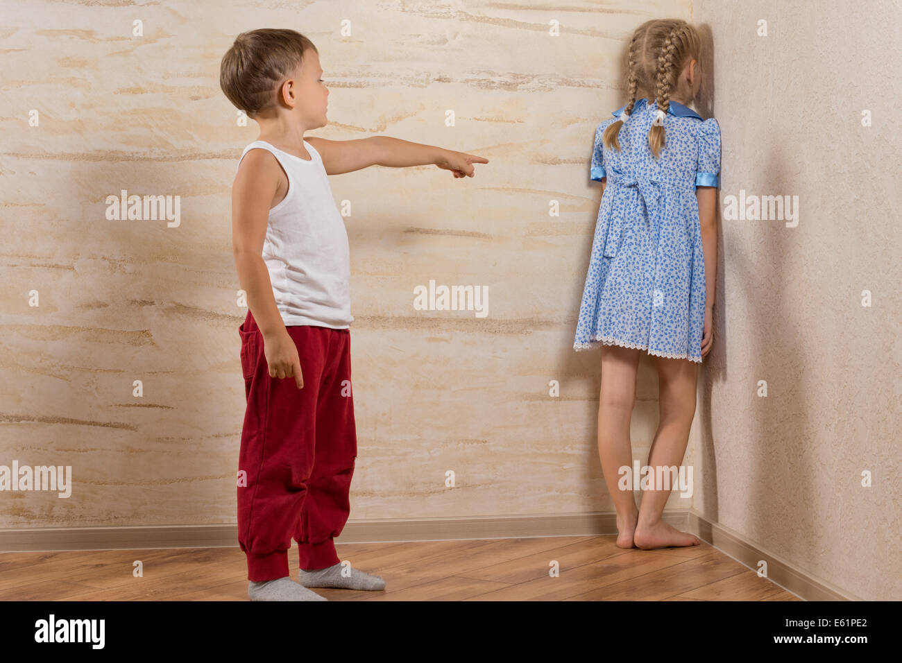 Zwei kleine Kinder spielen zu Hause, während Eltern unterwegs sind, isoliert auf Holzwände Stockfoto