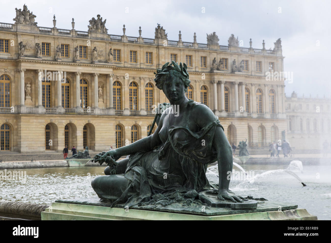 Skulpturen und Statuen in den Gärten von Versailles mit dem Schloss von