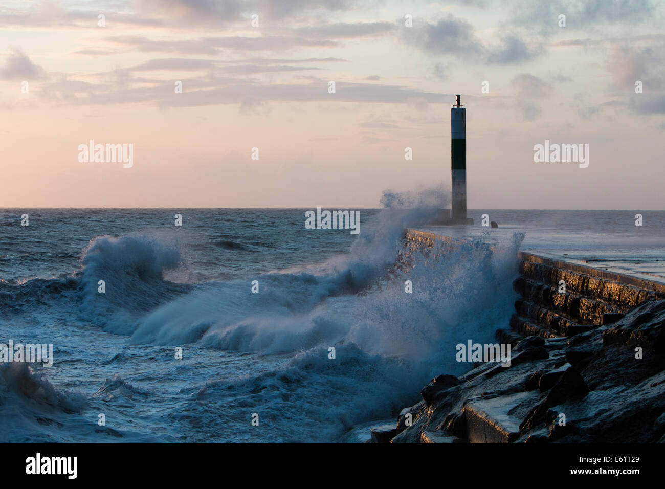 Aberystwyth, Wales, UK. 11. August 2014. Gepeitscht bis durch den Sturm namens Bertha Meer stürzt Wellen gegen den Leuchtturm in Aberystwyth bei Sonnenuntergang. Bildnachweis: Jon Freeman/Alamy Live-Nachrichten Stockfoto