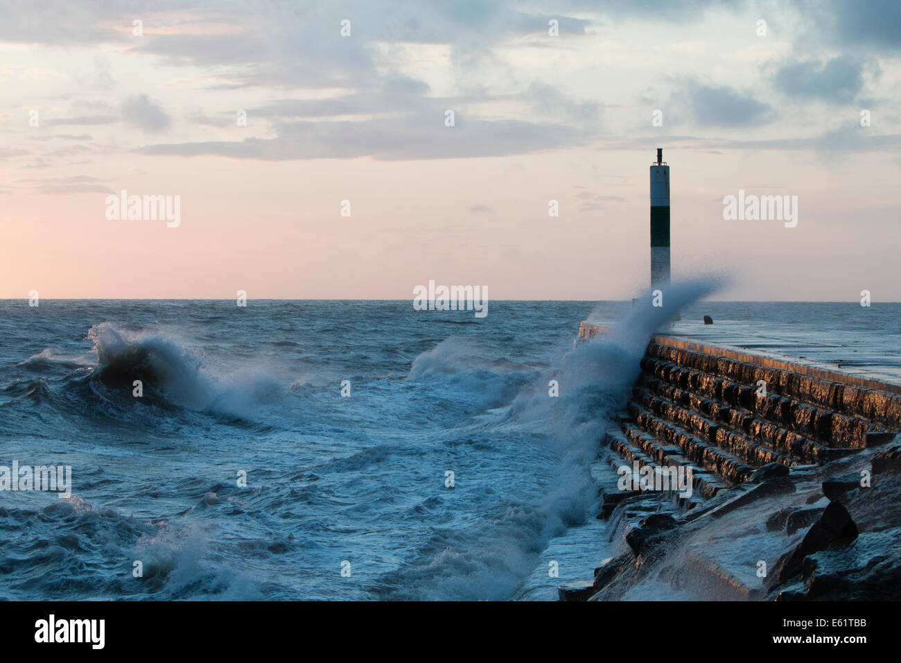 Aberystwyth, Wales, UK. 11. August 2014. Gepeitscht bis durch den Sturm namens Bertha Meer stürzt Wellen gegen den Leuchtturm in Aberystwyth bei Sonnenuntergang. Bildnachweis: Jon Freeman/Alamy Live-Nachrichten Stockfoto