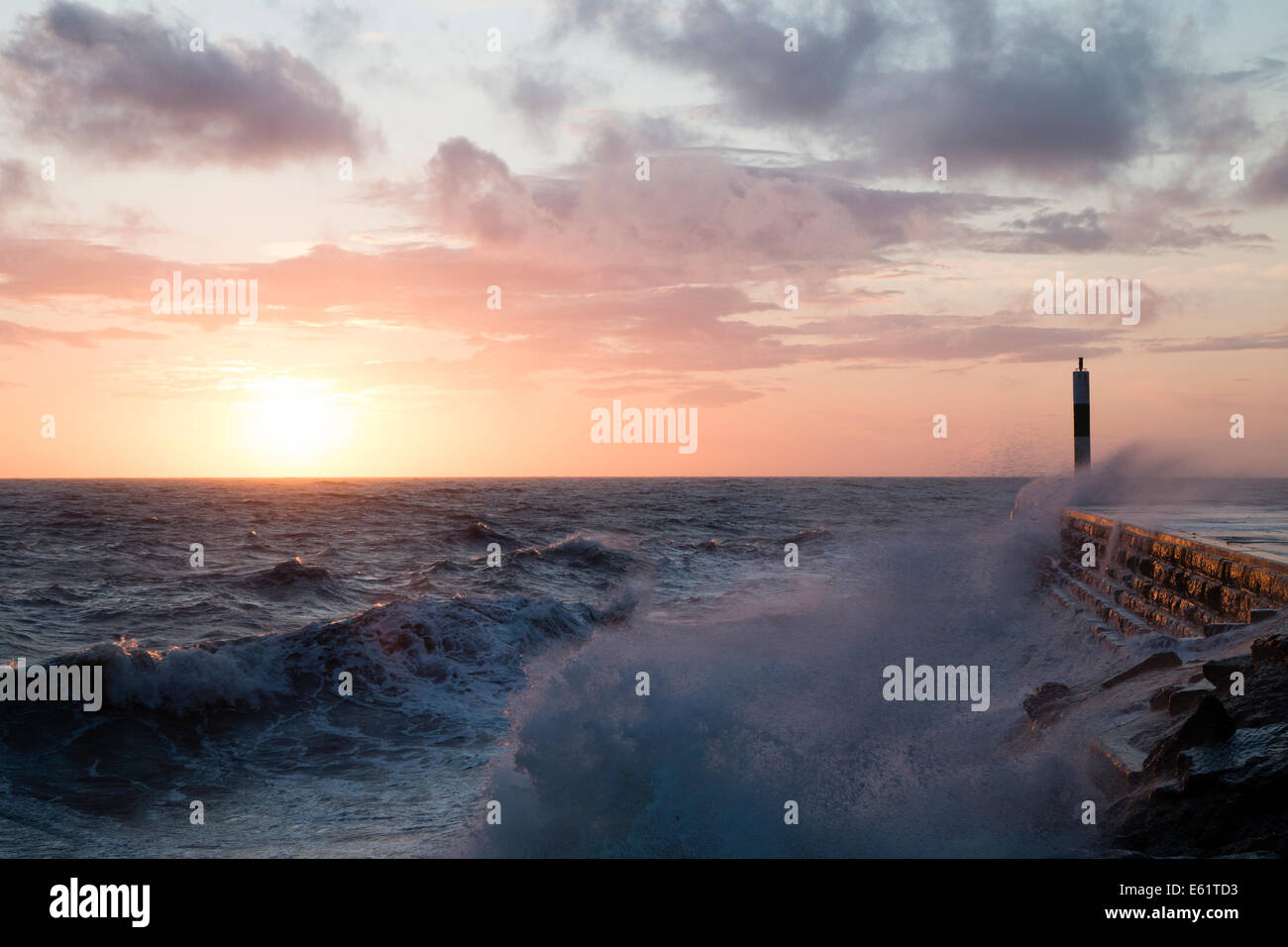 Aberystwyth, Wales, UK. 11. August 2014. Gepeitscht bis durch den Sturm namens Bertha Meer stürzt Wellen gegen den Leuchtturm in Aberystwyth bei Sonnenuntergang. Bildnachweis: Jon Freeman/Alamy Live-Nachrichten Stockfoto