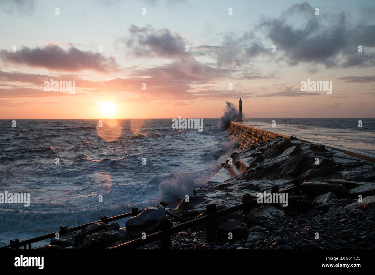Aberystwyth, Wales, UK. 11. August 2014. Gepeitscht bis durch den Sturm namens Bertha Meer stürzt Wellen gegen den Leuchtturm in Aberystwyth bei Sonnenuntergang. Bildnachweis: Jon Freeman/Alamy Live-Nachrichten Stockfoto