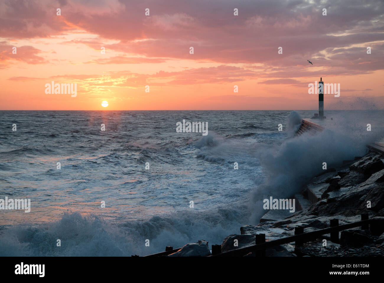 Aberystwyth, Wales, UK. 11. August 2014. Gepeitscht bis durch den Sturm namens Bertha Meer stürzt Wellen gegen den Leuchtturm in Aberystwyth bei Sonnenuntergang. Bildnachweis: Jon Freeman/Alamy Live-Nachrichten Stockfoto