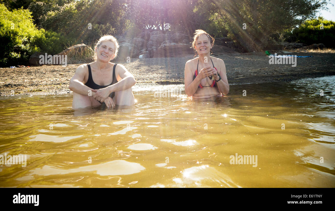 Zwei Frauen sitzen im Wasser Stockfoto
