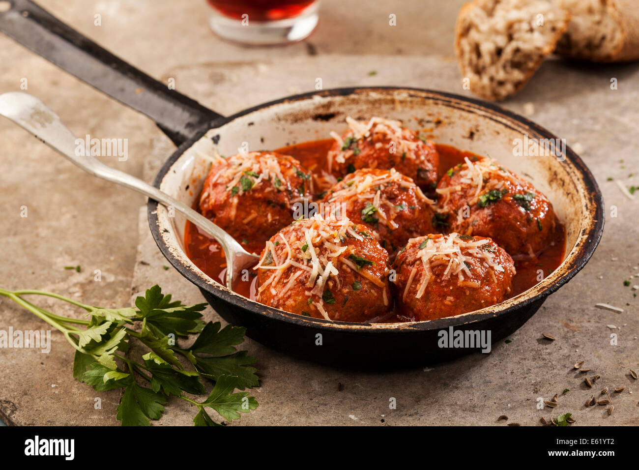 Fleischbällchen in Tomatensauce in Pfanne auf grauem Hintergrund gekocht Stockfoto