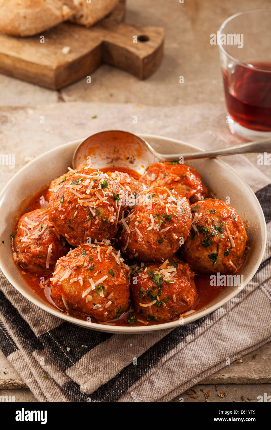 Fleischbällchen in Tomatensauce in Schüssel auf grauem Hintergrund gekocht Stockfoto