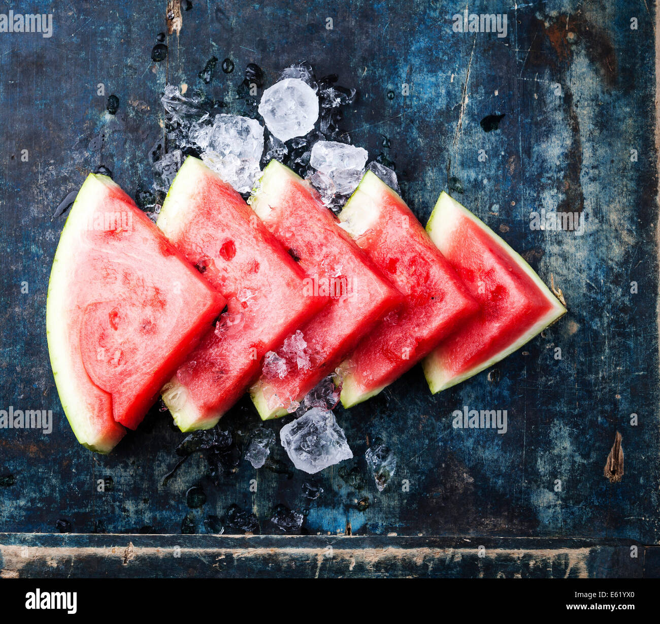 Wassermelone-Scheiben und Eis auf blauem Hintergrund Stockfoto