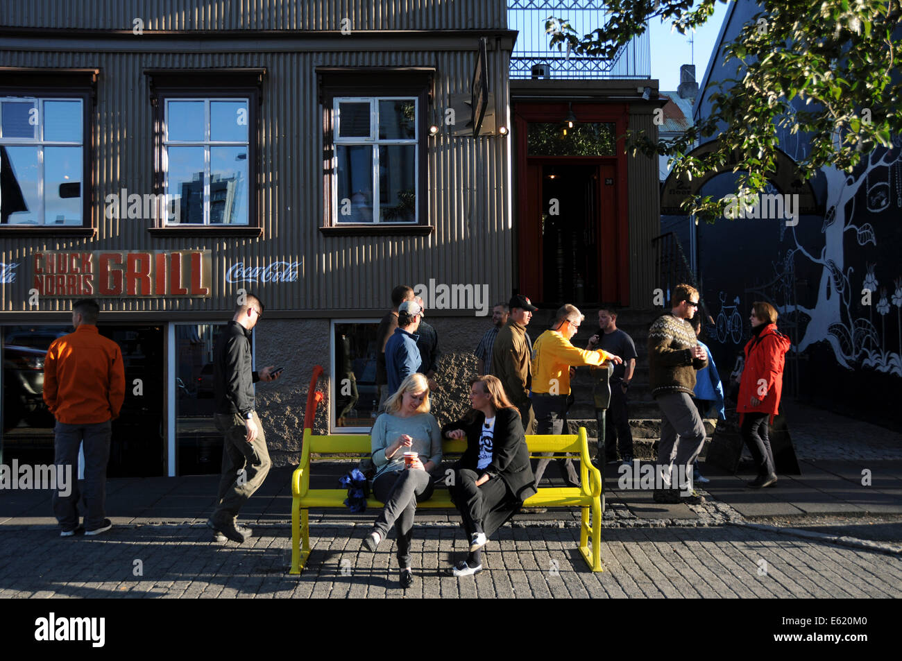 Menschen, Geschäfte, Seite zu Fuß Restaurants und Pubs in Laugavegur Straße im Zentrum von Reykjavik an einem sonnigen Tag in Island Stockfoto