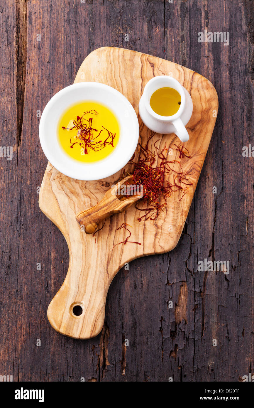 Olivenöl mit Safran auf dunklem Holz Stockfoto