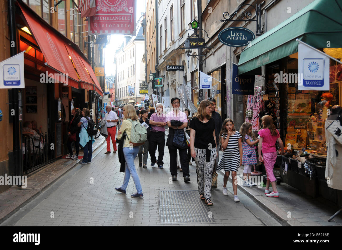 Leben auf der Straße in Stockholm mit Bürgersteig Restaurants, Coffee-Shops, Fußgänger entlang der gepflasterten Straßen in der Altstadt Stockfoto