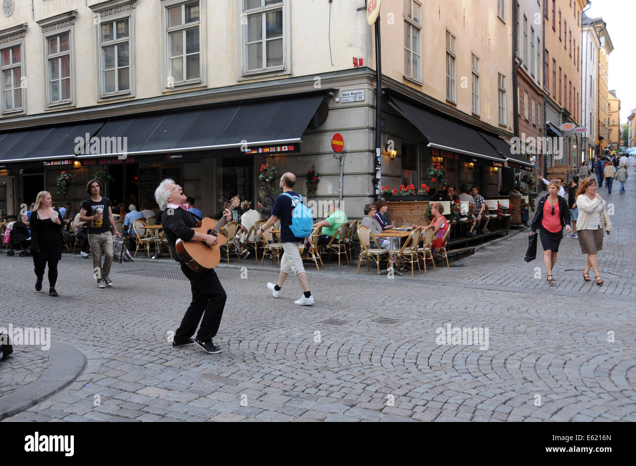 Leben auf der Straße im alten Stockholm mit Bürgersteig Restaurants, Coffee-Shops, Fußgänger und Musikern entlang der gepflasterten Straßen Stockfoto
